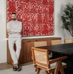 Kevin Love standing in front of a red Rashid Johnson painting