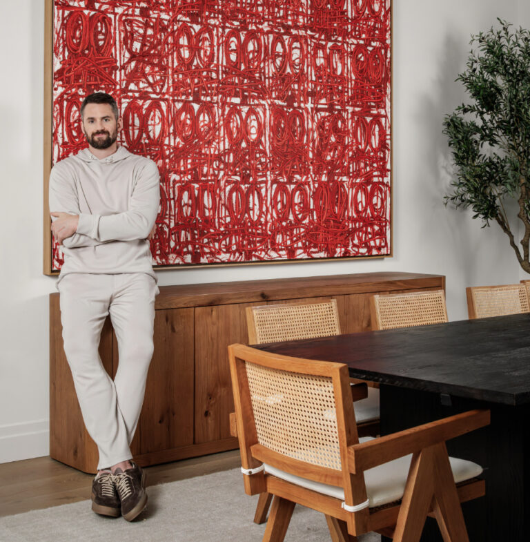Kevin Love standing in front of a red Rashid Johnson painting