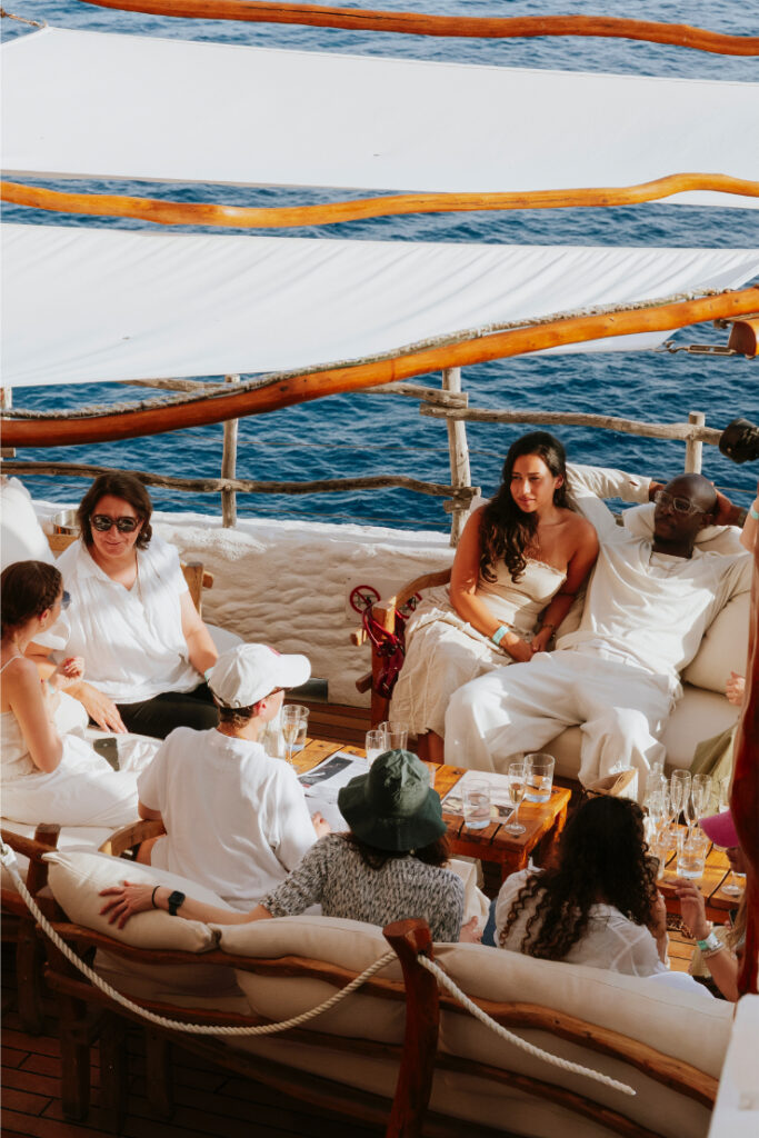 Group of people sitting around by the sea