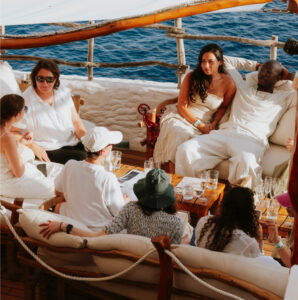 Group of people sitting around by the sea
