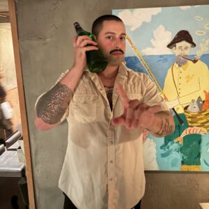 A bartender poses for a portrait with a drink
